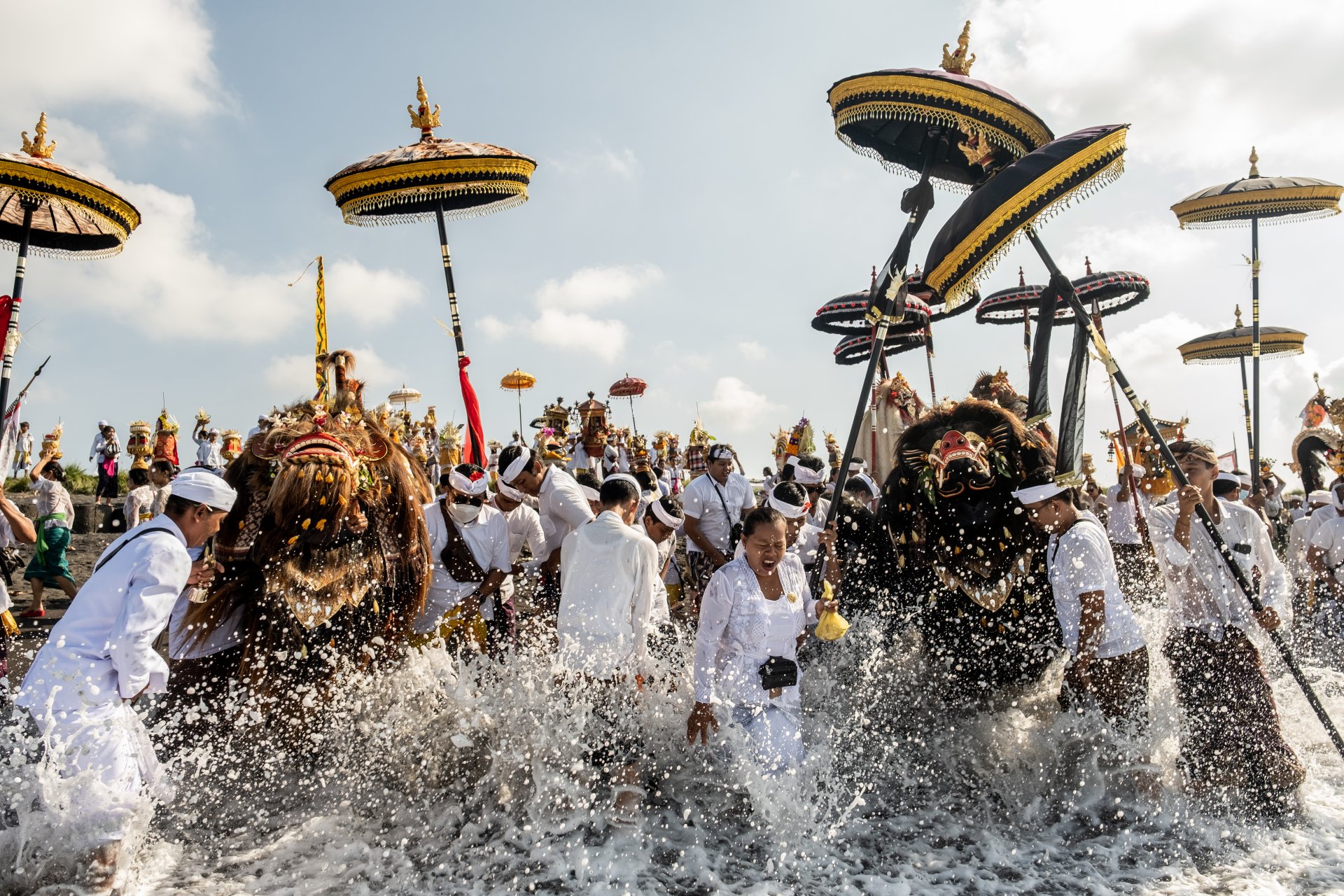 Балийските индуси носят свещени маски и ритуални принадлежности по време на Меласти преди Деня на Ниепи. Снимката е от плажа Сиют, в Гианяр Бали, Индонезия. 