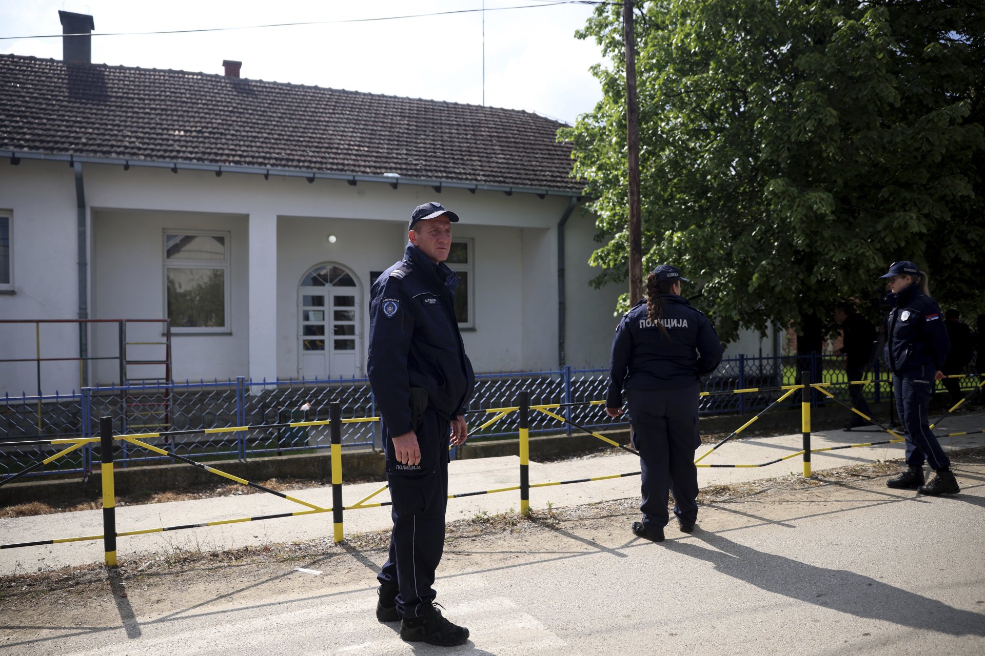 Полицейски служители стоят на пост до училищния двор в село Дубона