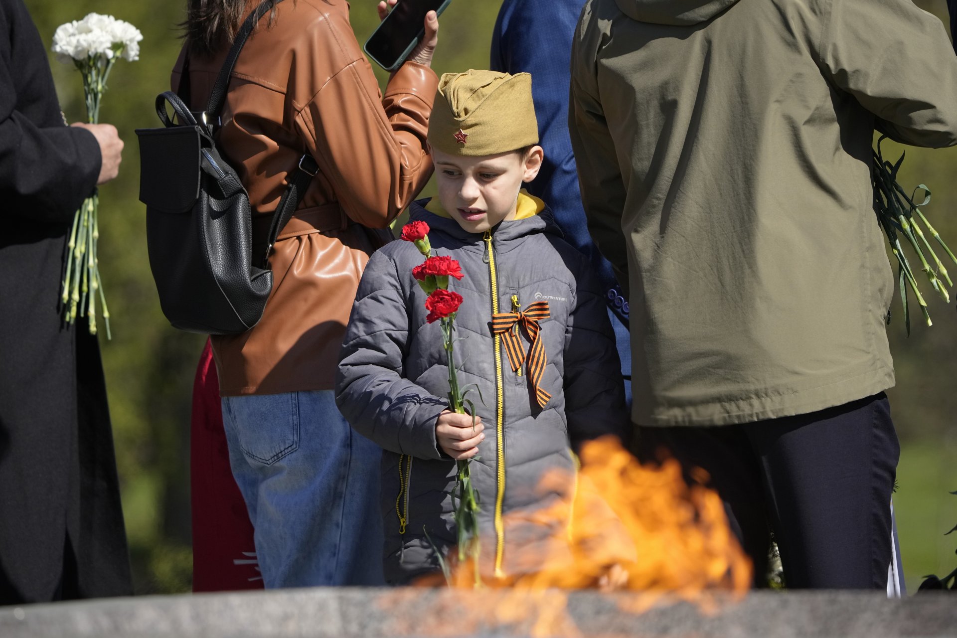 Момче стои до вечния огън по време на церемония по полагане на цветя и венци на Пискарьовското гробище, където са погребани повечето от жертвите на обсадата на Ленинград по време на Втората световна война