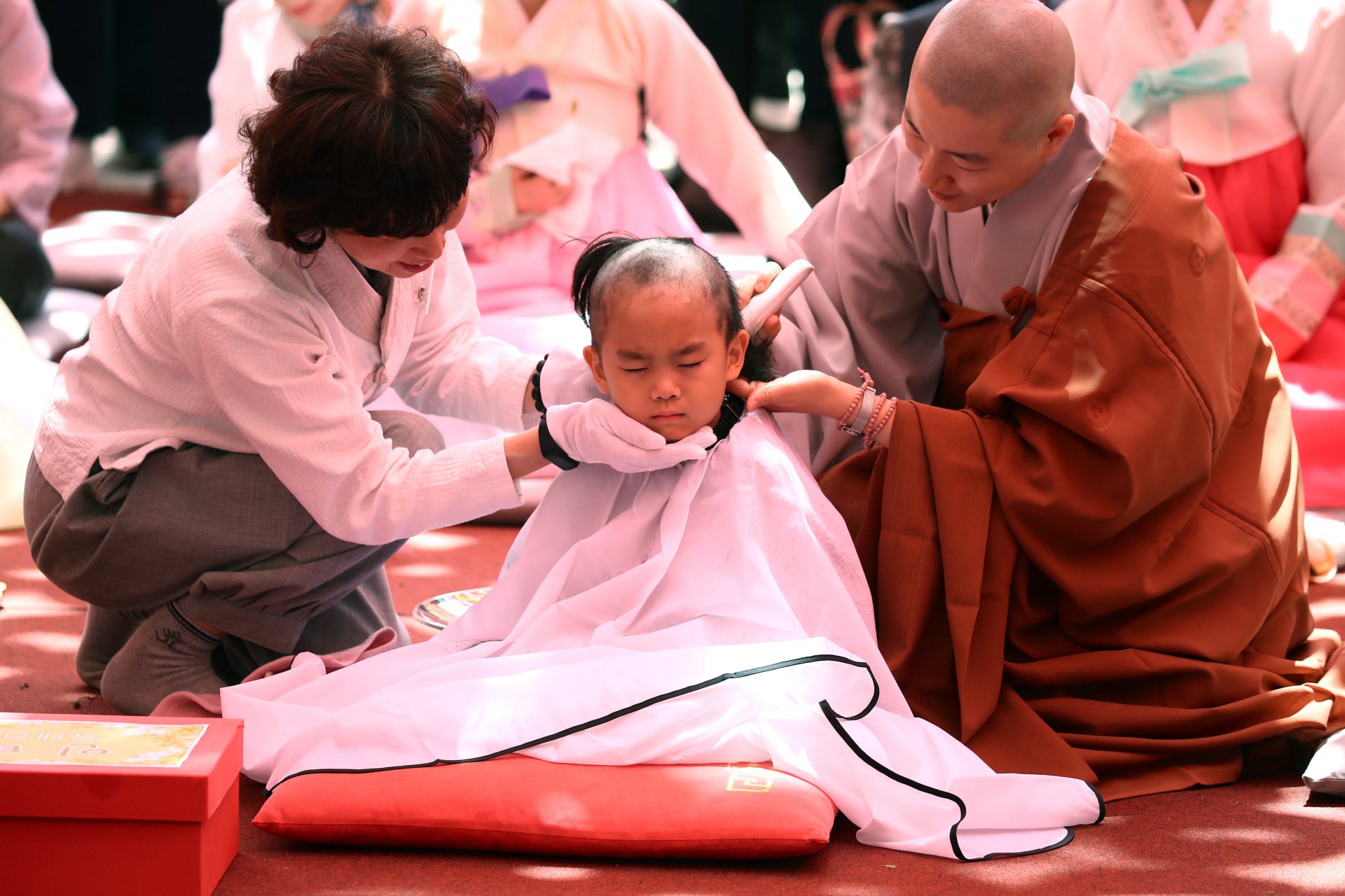Moнах бръсне главата на дете, което се подготвя да живеее в отшелничество в продължение на три седмици в храма Джогеса на 09 май 2023 г. в Сеул, Южна Корея. 