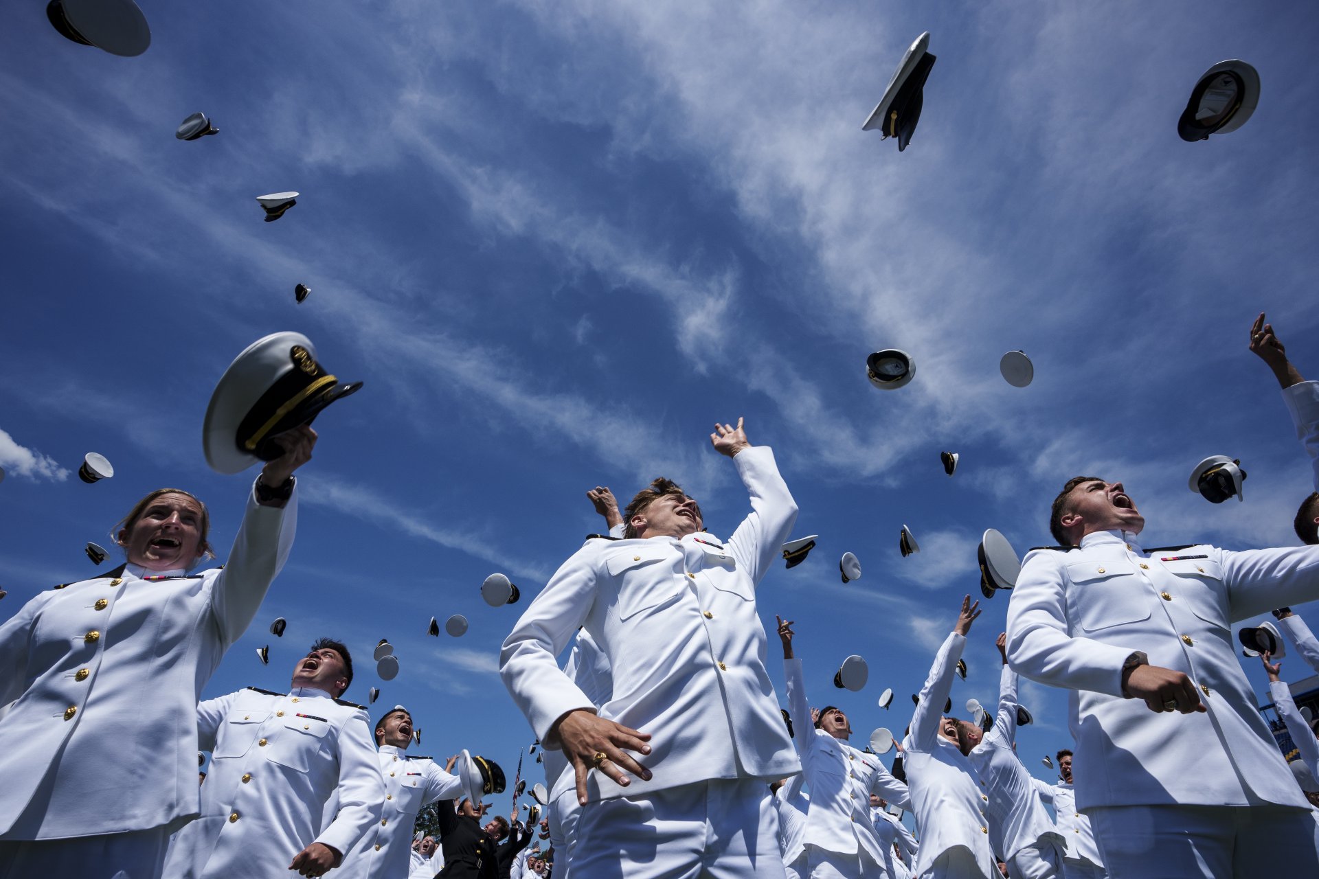 Завършващите мичмани хвърлят шапките си във въздуха по време на церемонията по дипломирането и пускането в експлоатация на Военноморската академия на САЩ на 26 май 2023 г. в Анаполис, Мериленд. 