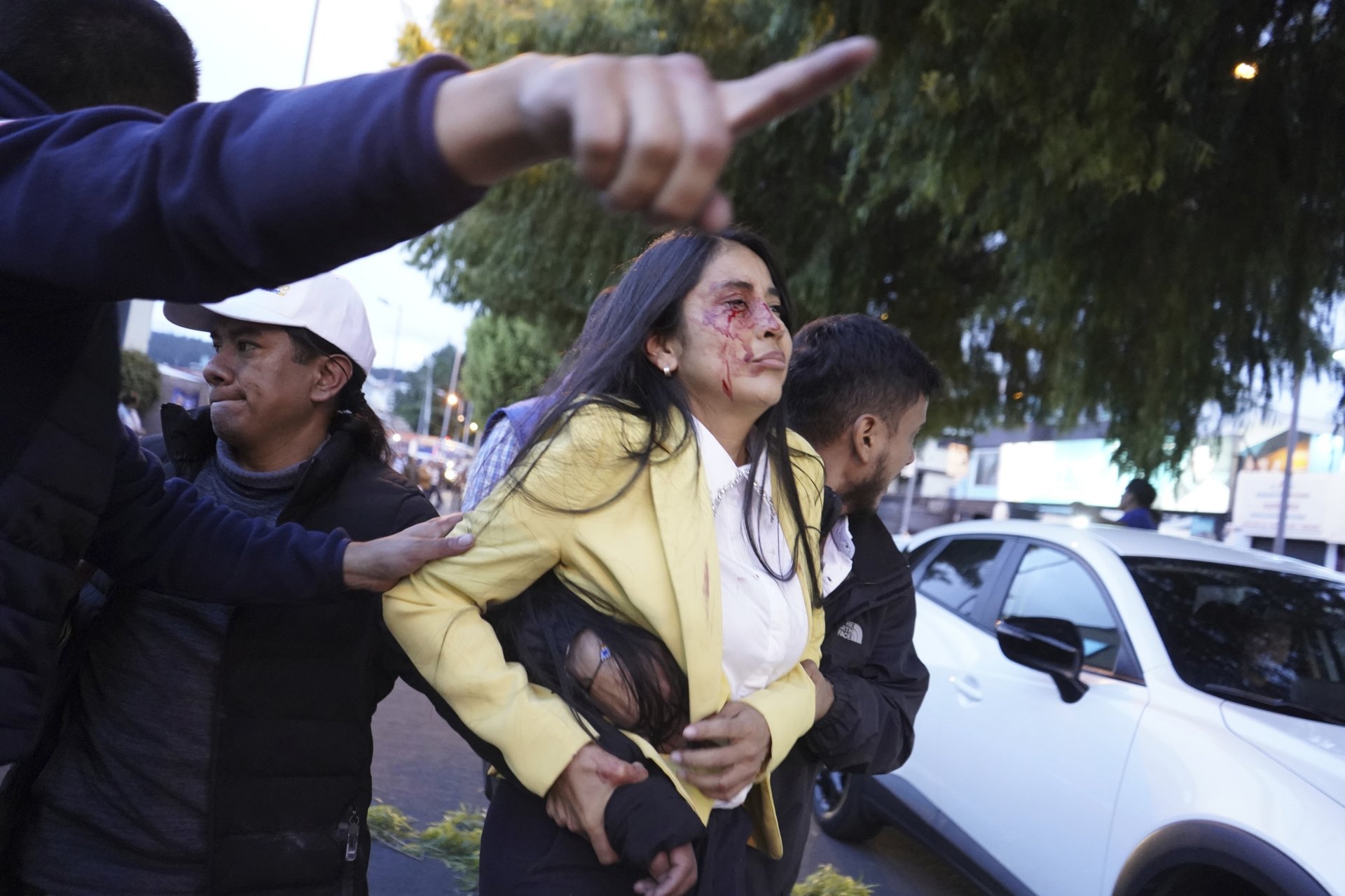 Полицията отвежда ранена жена след убийството на кандидат-президента на Еквадор Фернандо Вилявисенсио 