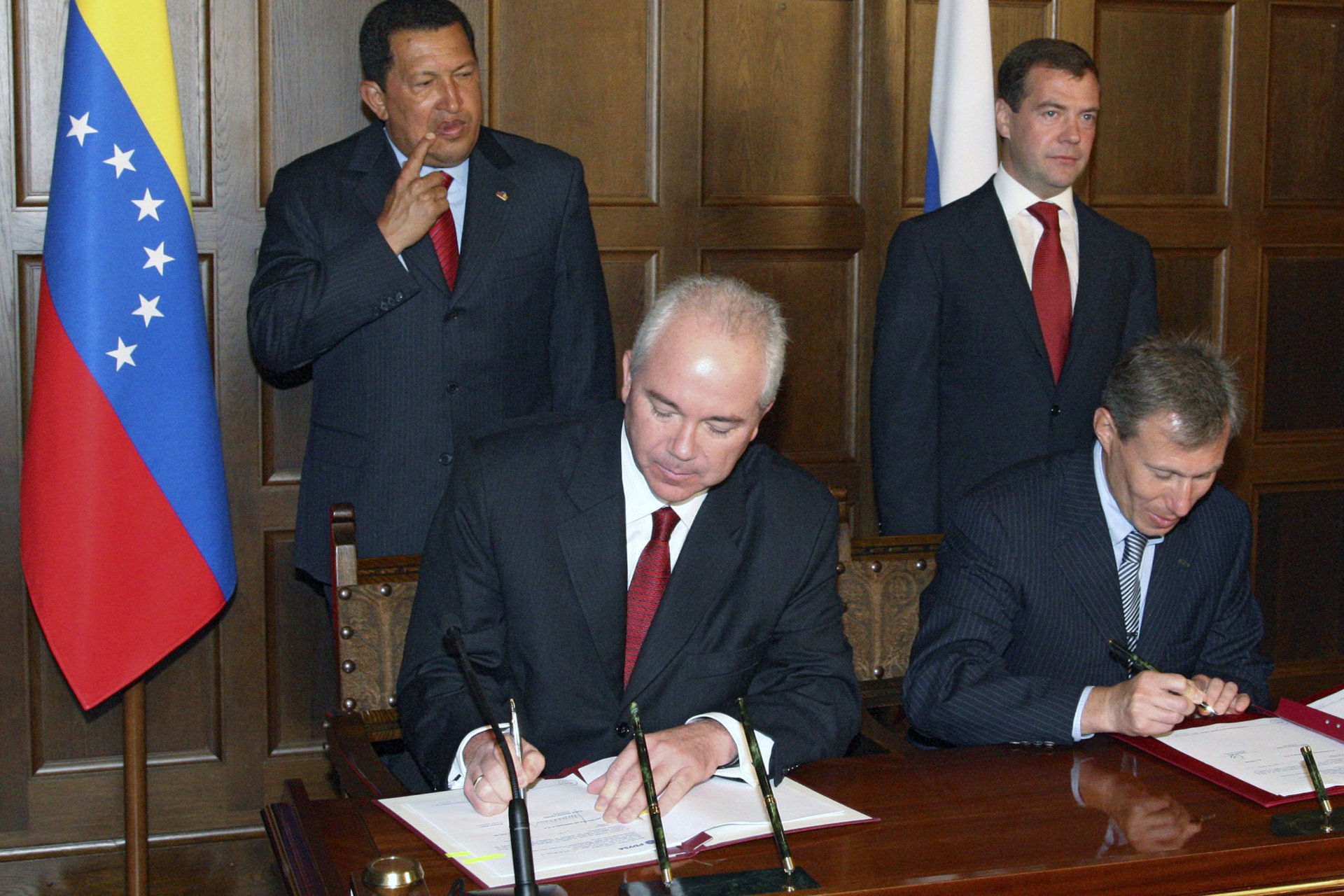 Герман Хан (TNK-BP) на преден план вляво подписва документи, над него вдясно е руският президент Дмитрий Медведев, до когото е президентът на Венецуела Уго Чавес, Москва, 22 юли 2008 г.