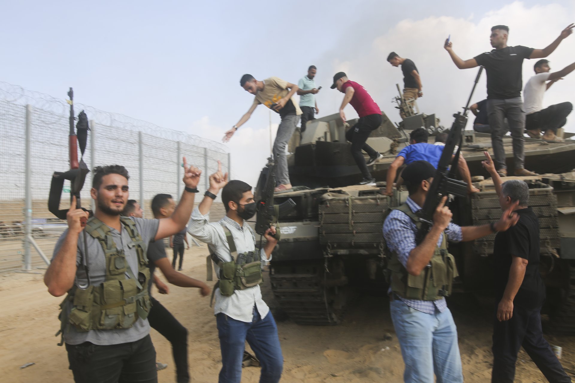 Палестинските екстремисти празнуват с израелски танк на граничната ограда на Ивицата Газа в събота, 7 октомври