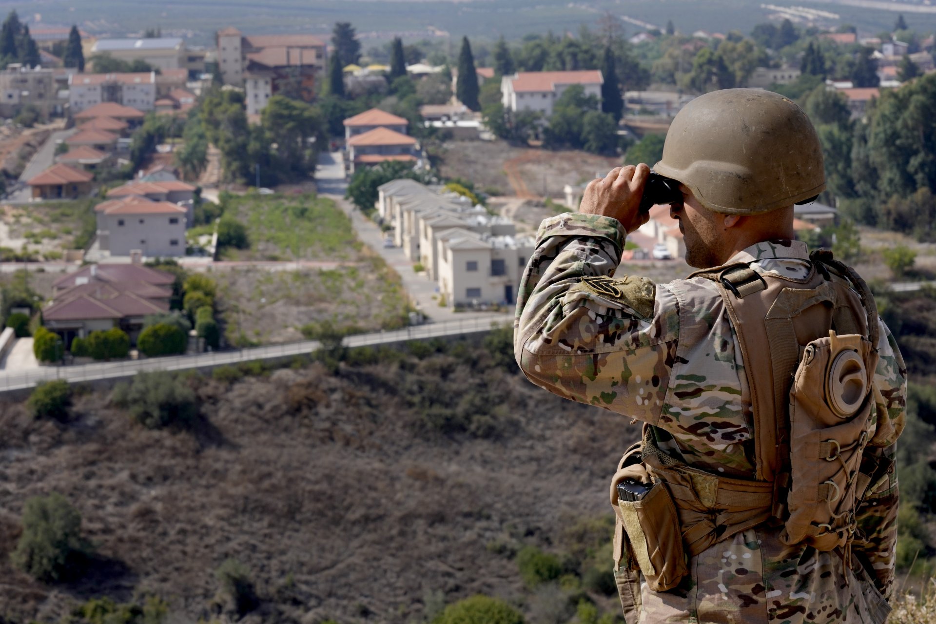Ливански войник наблюдава с бинокъл израелския град Метула, разположен близо до границата