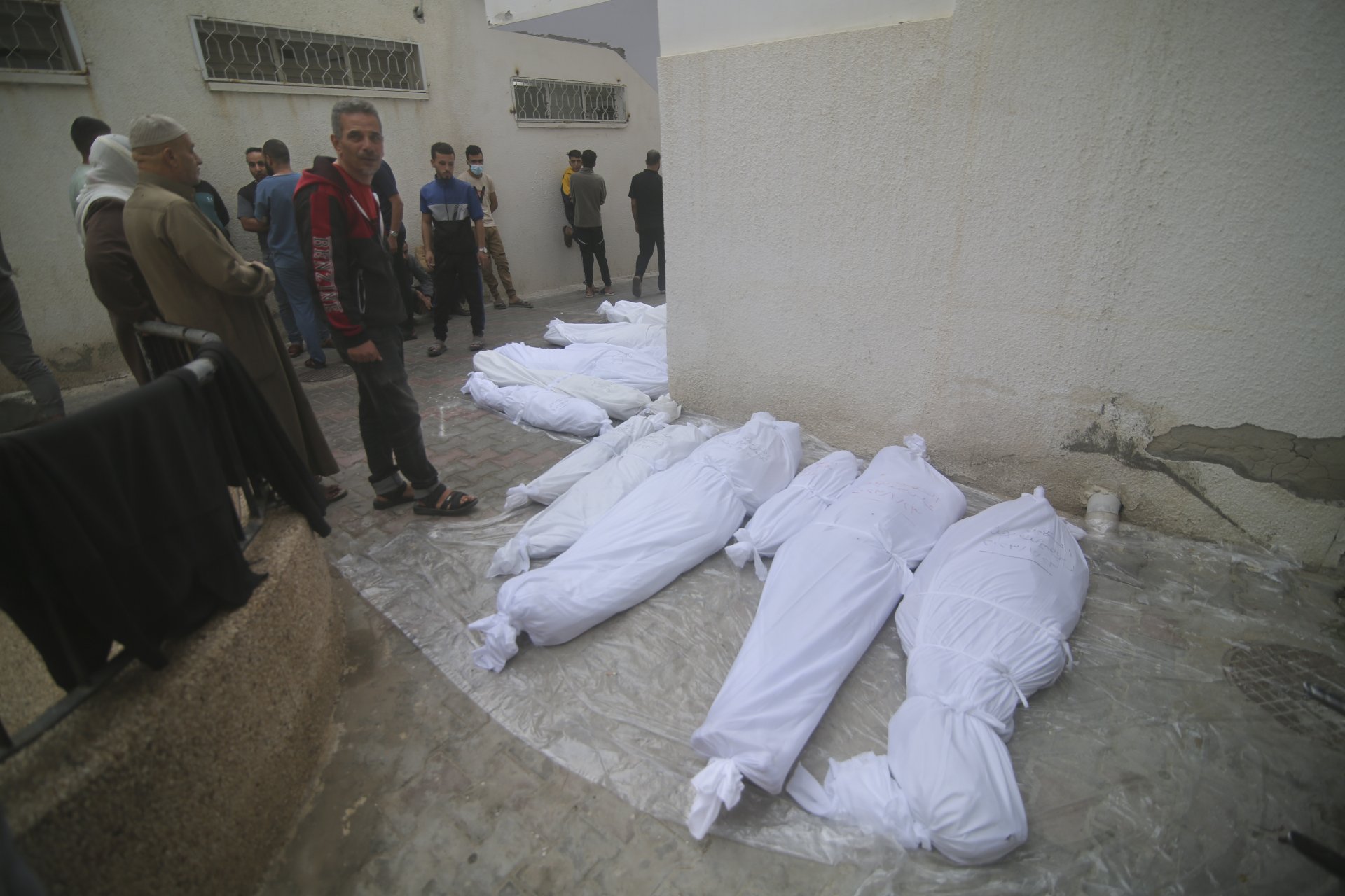 Палестинците стоят до телата на своите роднини, убити при израелската бомбардировка на ивицата Газа в Рафа, понеделник, октомври. 23, 2023 г.