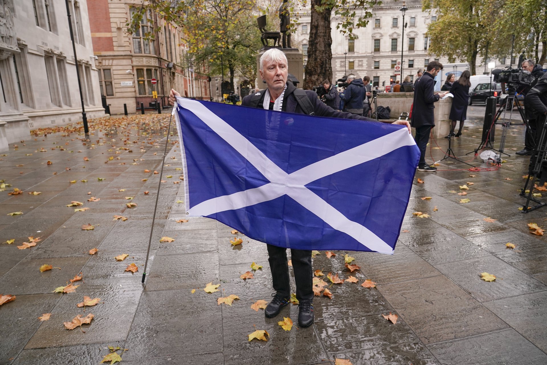Протестиращ държи шотландския флаг пред сградата на Върховния съд в Лондон