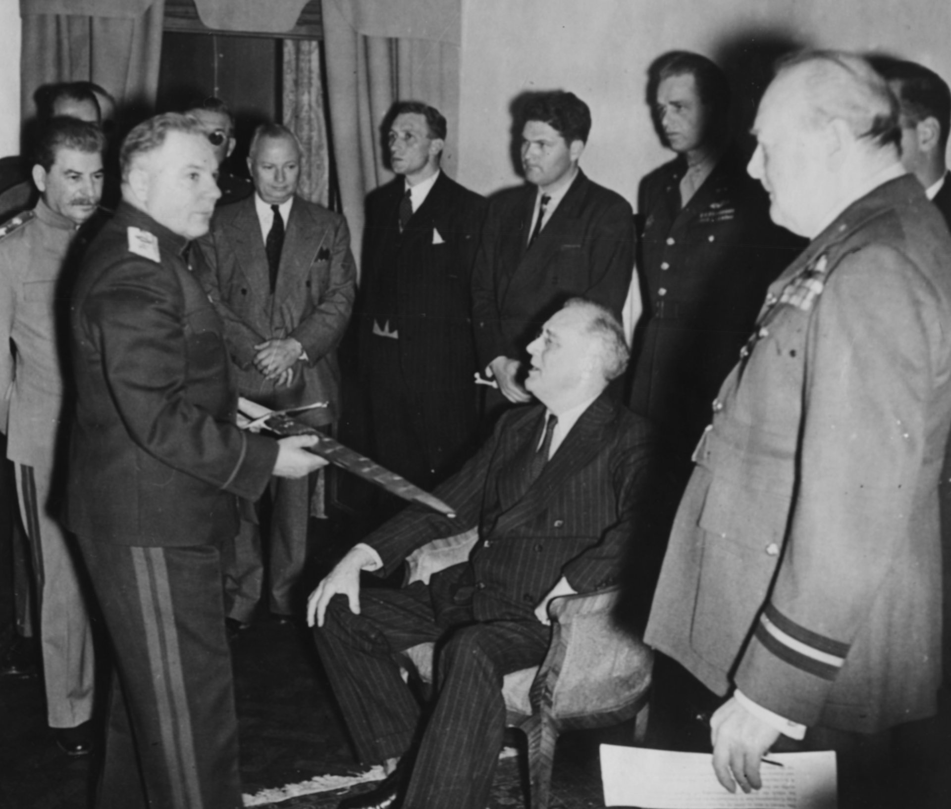 8 декември 1943 г. - Офицер Климент Ворошилов показва меча Сталинград на американския президент Франклин Делано Рузвелт, наблюдаван от британския министър-председател Уинстън Чърчил (вдясно), съветския лидер Йосиф Сталин (вляво) и полковник Елиът Рузвелт (зад баща си в униформа) по време на Техеранската конференция.