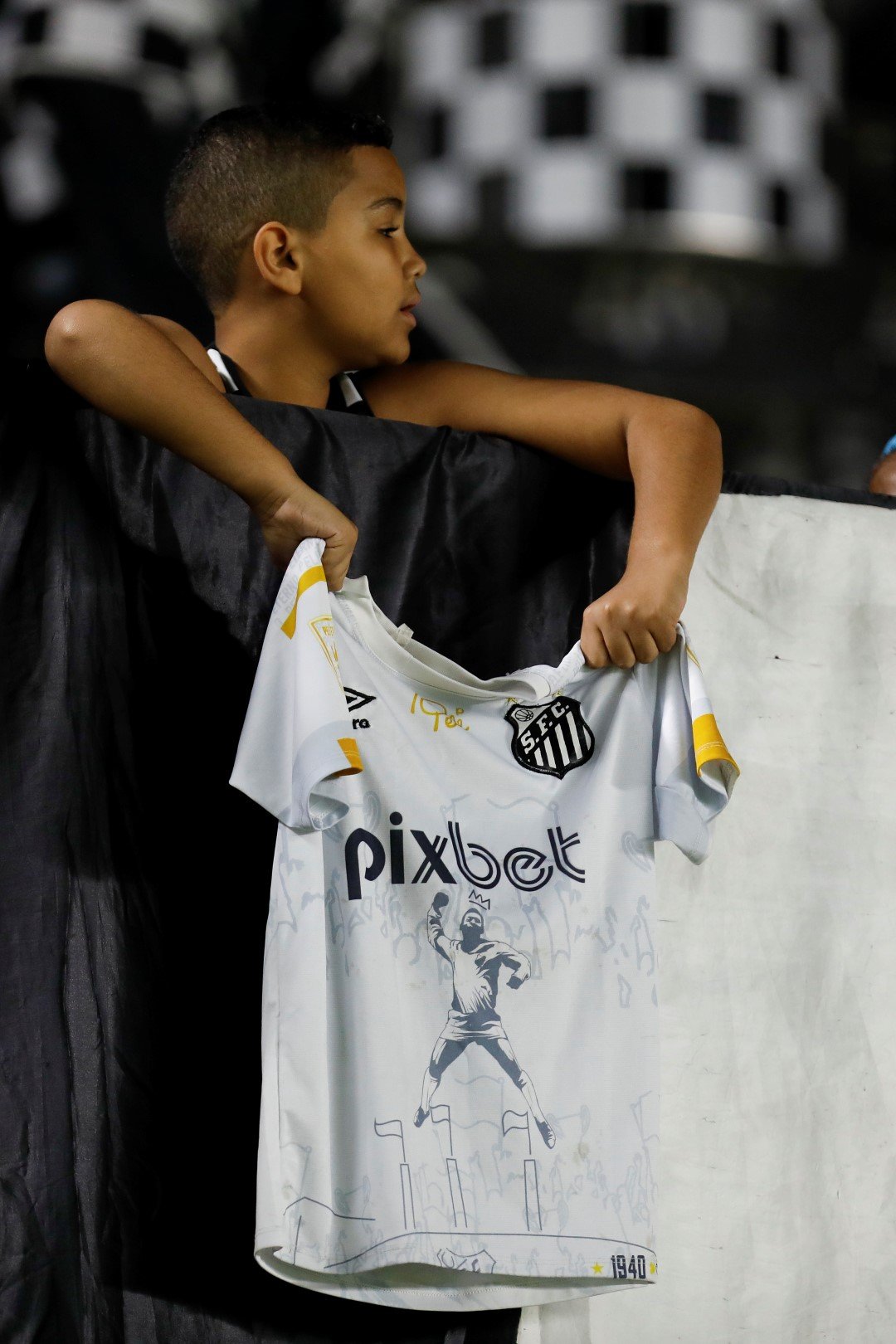 Малък и тъжен фен на Сантос държи фланелка с лика на Пеле. Клубът за първи път изпадна от елита на Бразилия