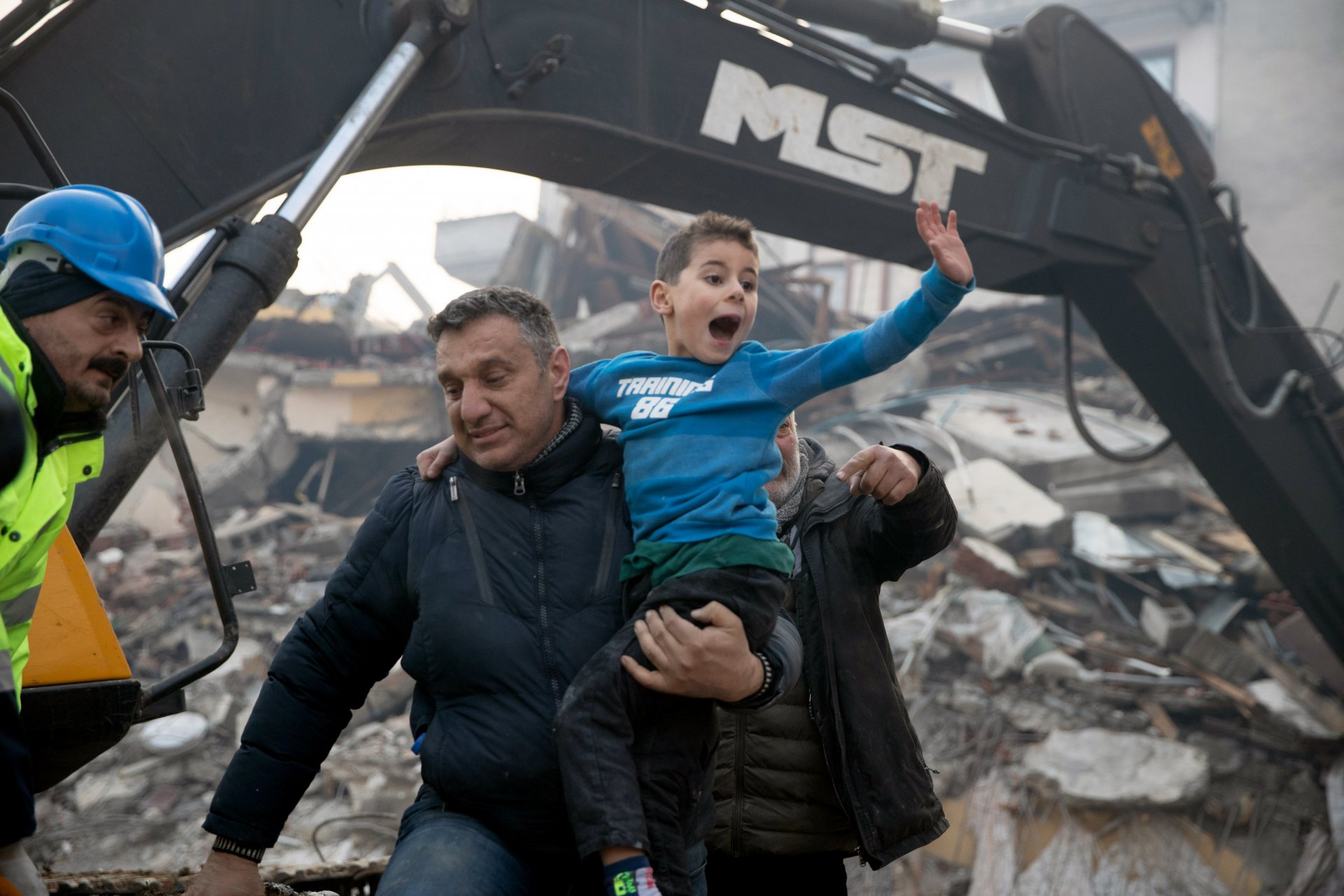 Спасители носят на ръце 8-годишния оцелял Йигит, изваден изпод руините на срутена сграда 52 часа след земетресението. Снимката е на Бурак Кара.