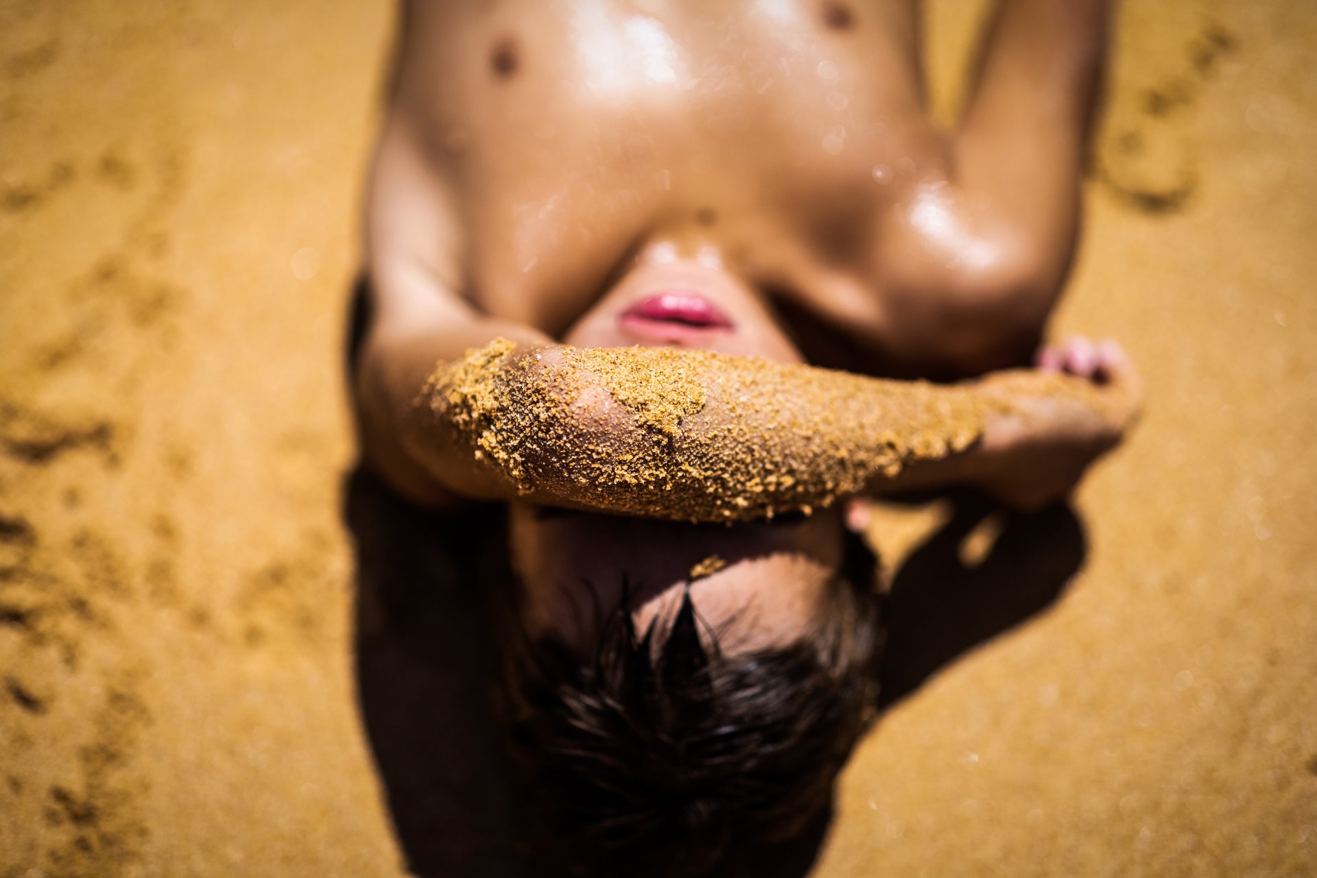 Момче се излежава в пясъка, скривайки лицето си от слънцето в Сидни, Австралия. Инициативата е част от програмата Bush to Beach, която се провежда за осемнадесета година. 