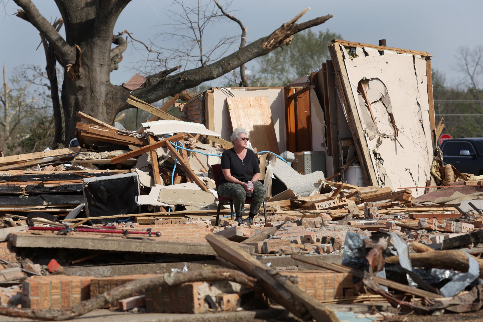 Жена сред развалините на дома си, унищожен от торнадото в Мисисипи