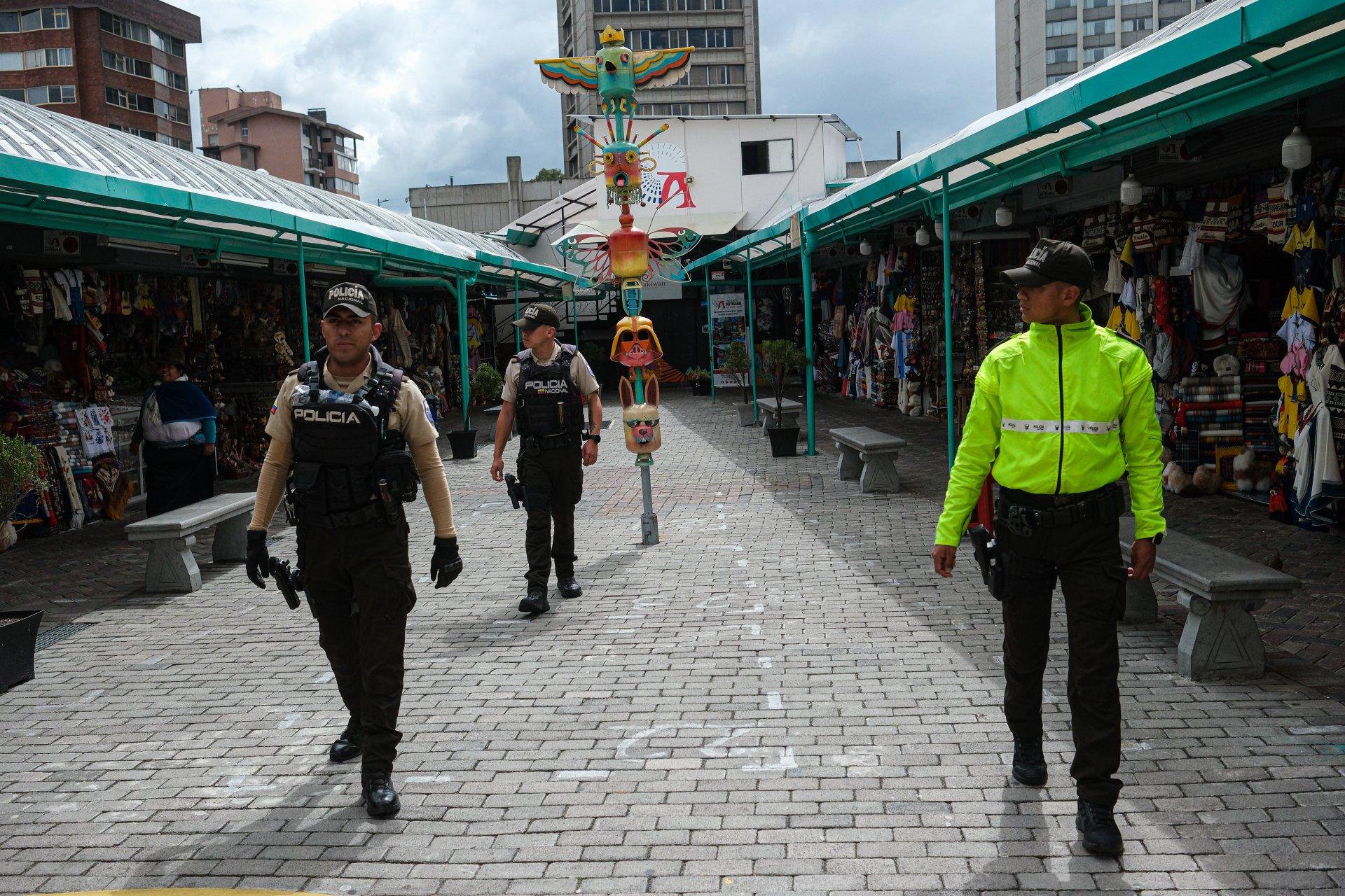 Полицейски служител се разхожда, охранявайки занаятчийски пазар на 10 януари 2024 г. в Кито, Еквадор. Президентът Нобоа обяви "вътрешен въоръжен конфликт", след като въоръжени мъже с качулки нахлуха в предаването на живо на TC Television, наред с други насилствени инциденти в цялата страна във вторник. Еквадор беше засегнат от експлозии, полицейски отвличания и безредици в затворите, откакто Нобоа в понеделник обяви извънредно положение в цялата страна, след като лидерът на бандата Адолфо "Фито" Масиас избяга от затвор в Гуаякил. 