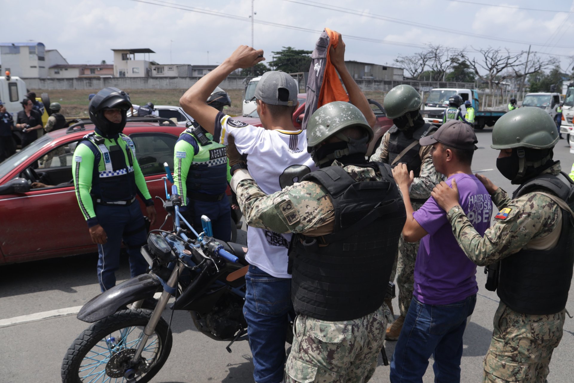 Военни офицери претърсват двама мъже на улица на 10 януари 2024 г. в Гуаякил, Еквадор. 