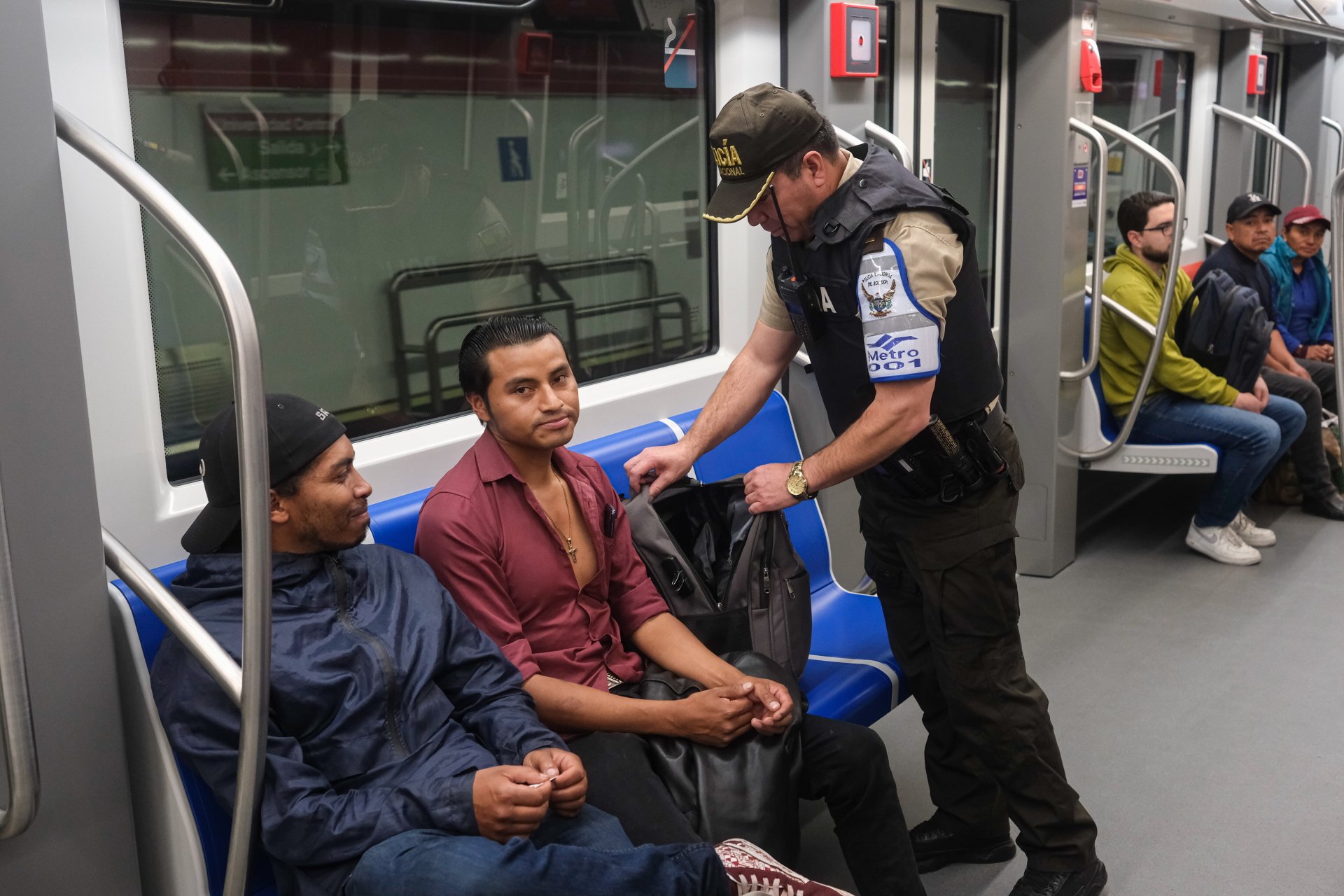 Полицейски служител проверява чантата на пътуващ в метрото 