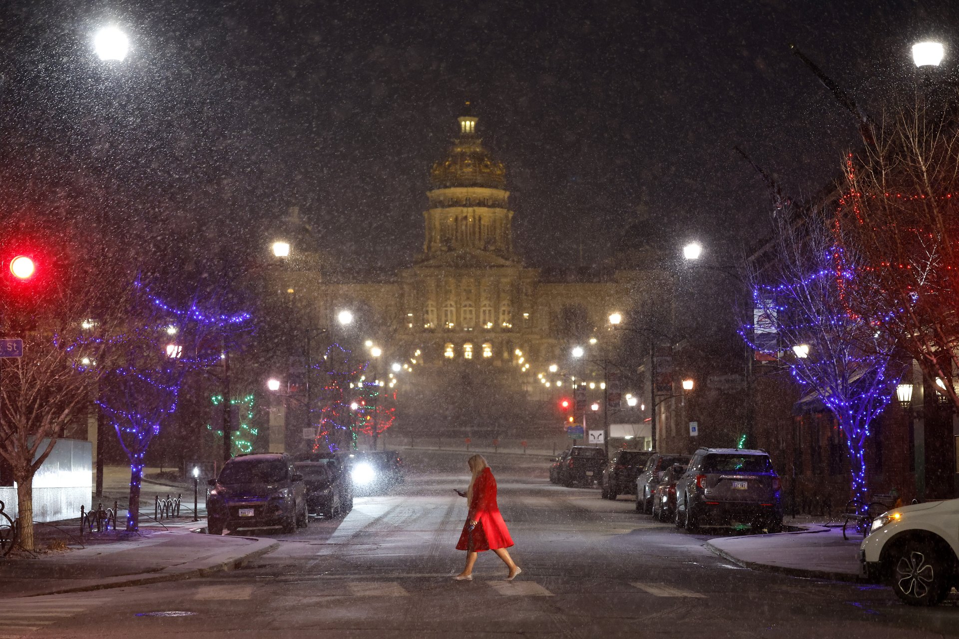 Жена пресича улица Локуст пред сградата на Капитолия на щата Айова, докато вали лек сняг. Зимното време принуди кандидата за президент на Републиканската партия Ники Хейли да отмени предизборно събитие по-рано през деня.