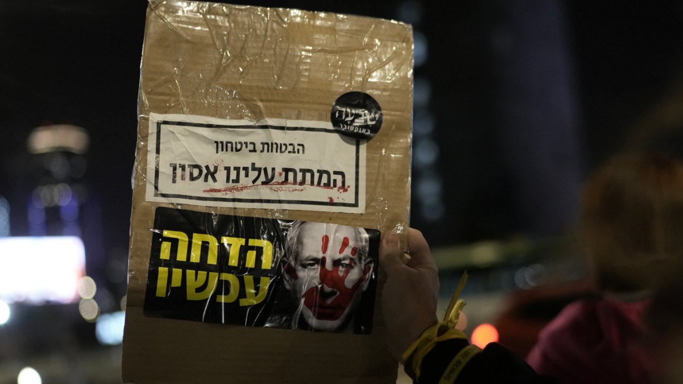 Протестиращ държи плакат със снимка на Нетаняху и надпис "Ти обещаваш сигурност. Ти ни донесе бедствие. Оставка сега"