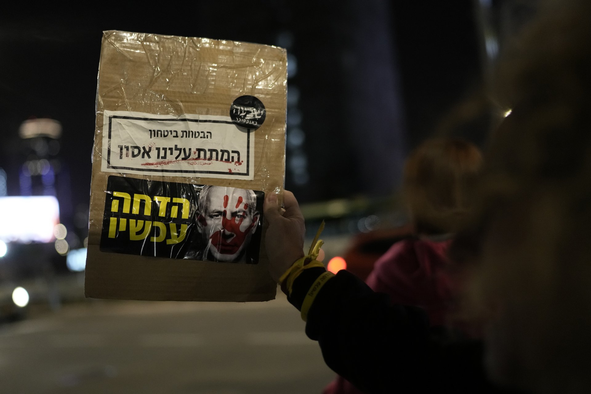 Протестиращ държи плакат със снимка на Нетаняху и надпис "Ти обещаваш сигурност. Ти ни донесе бедствие. Оставка сега"