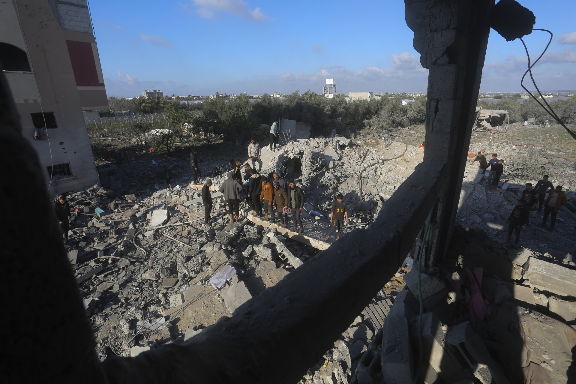  Палестинци търсят оживели след израелски въздушен удар по жилищна постройка в град Рафах в линията Газа, 10 февруари 2024 година 