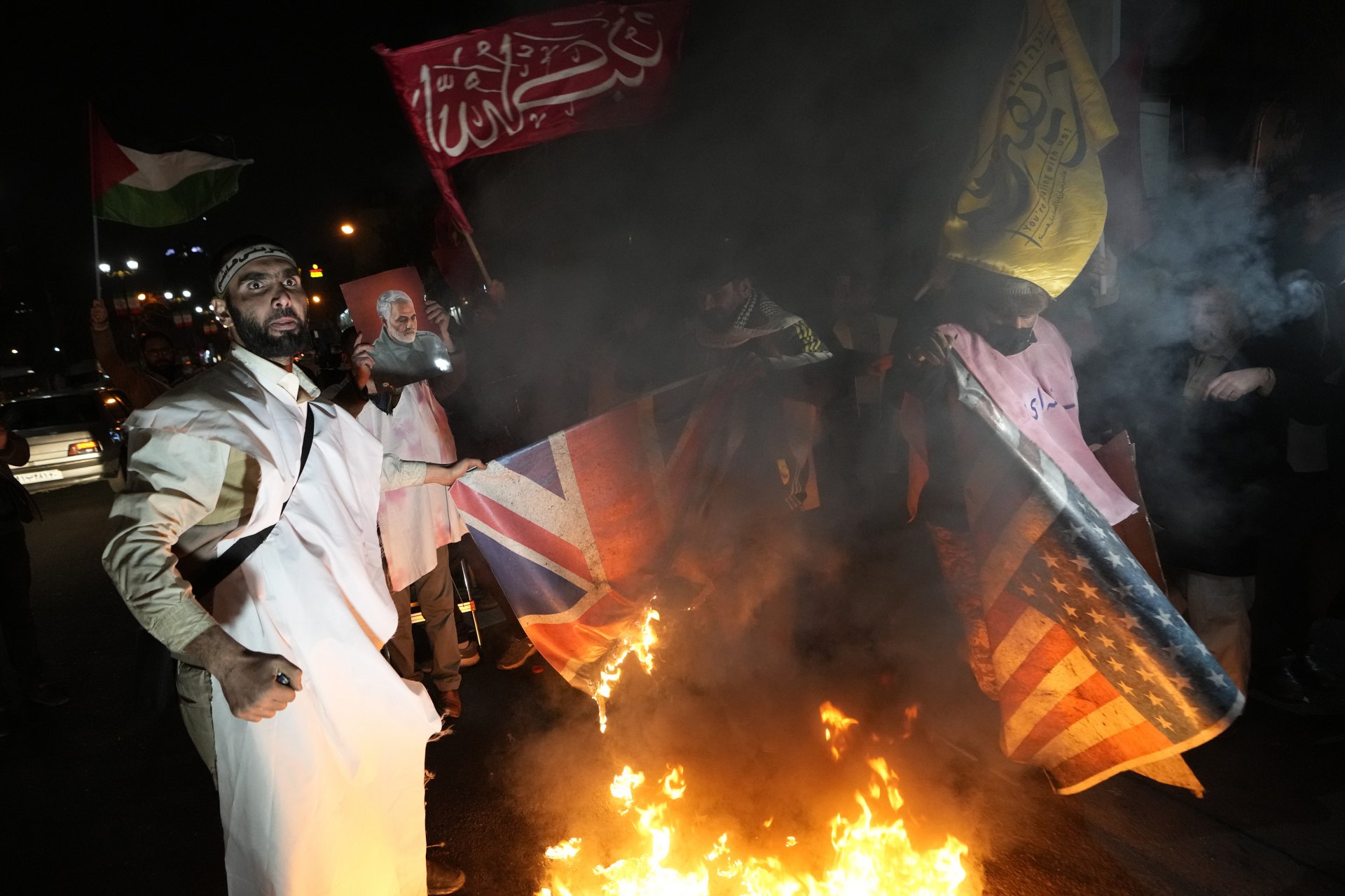 рански демонстранти изгарят в Техеран изображения на американското и британското знаме при протест срещу военните удари на САЩ и Великобритания срещу подкрепяните от Иран йеменски бунтовници хуси, 12 януари 2024 г.