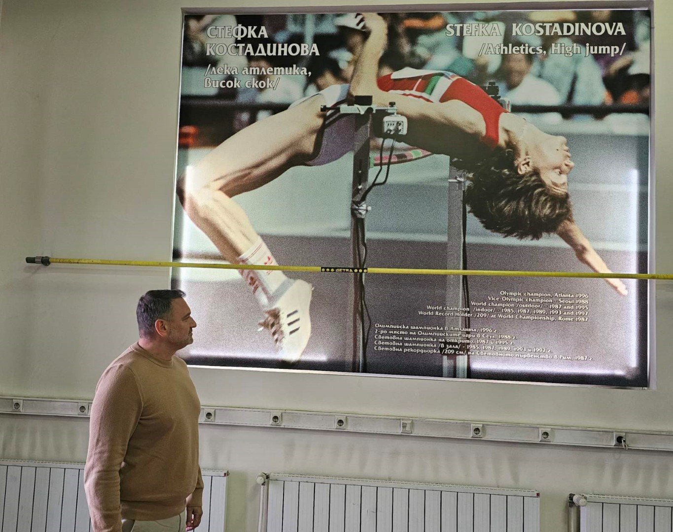 Шефът на федерацията гледа огромното пано за рекордния опит на Стефка Костадинова във високия скок, на стадион "Васил Левски"