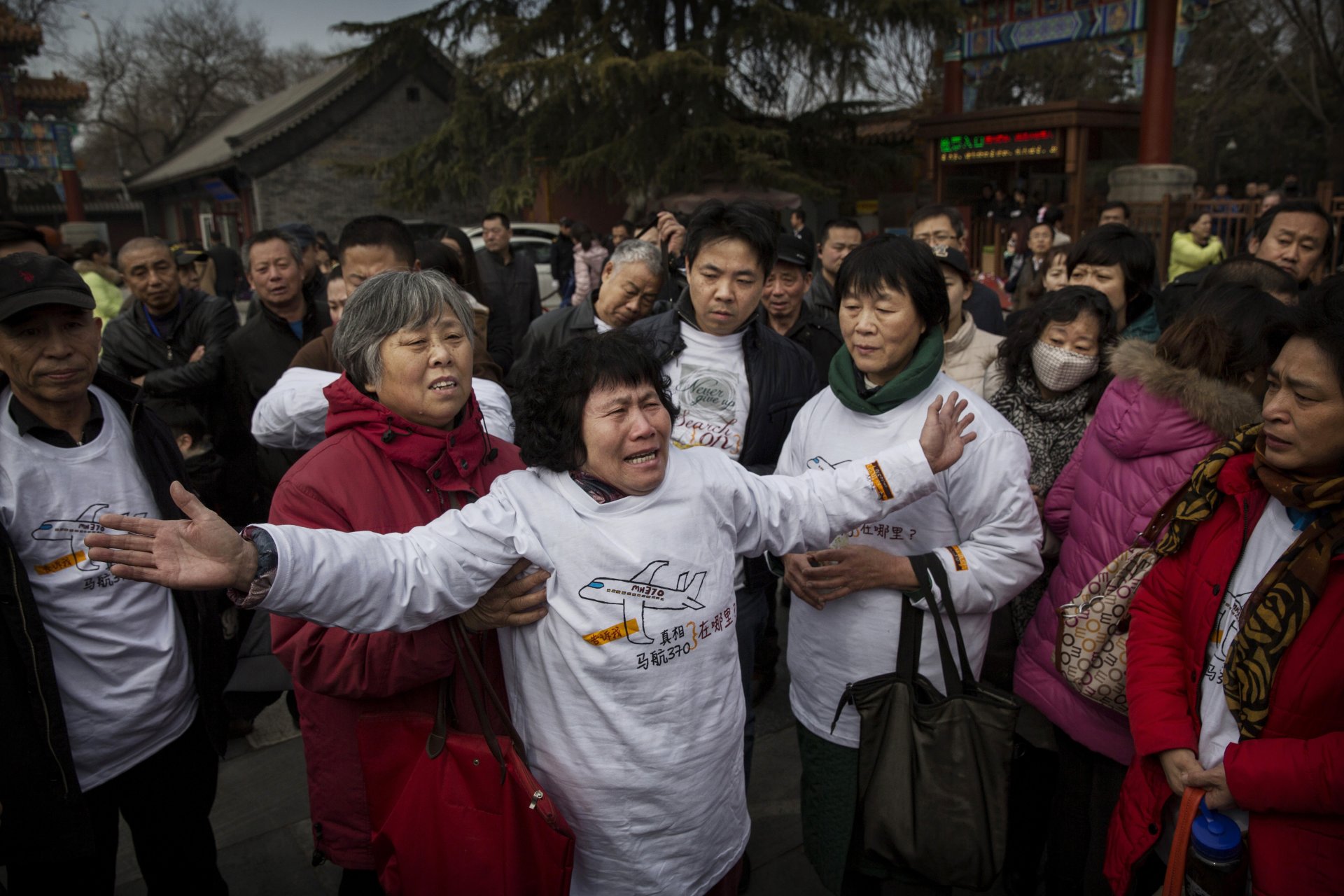 Китайски роднини на изчезнал пътник от полет MH370 на Malaysia Airlines плачат пред главната порта на храма на Лама на 8 март 2015 г. в Пекин, Китай