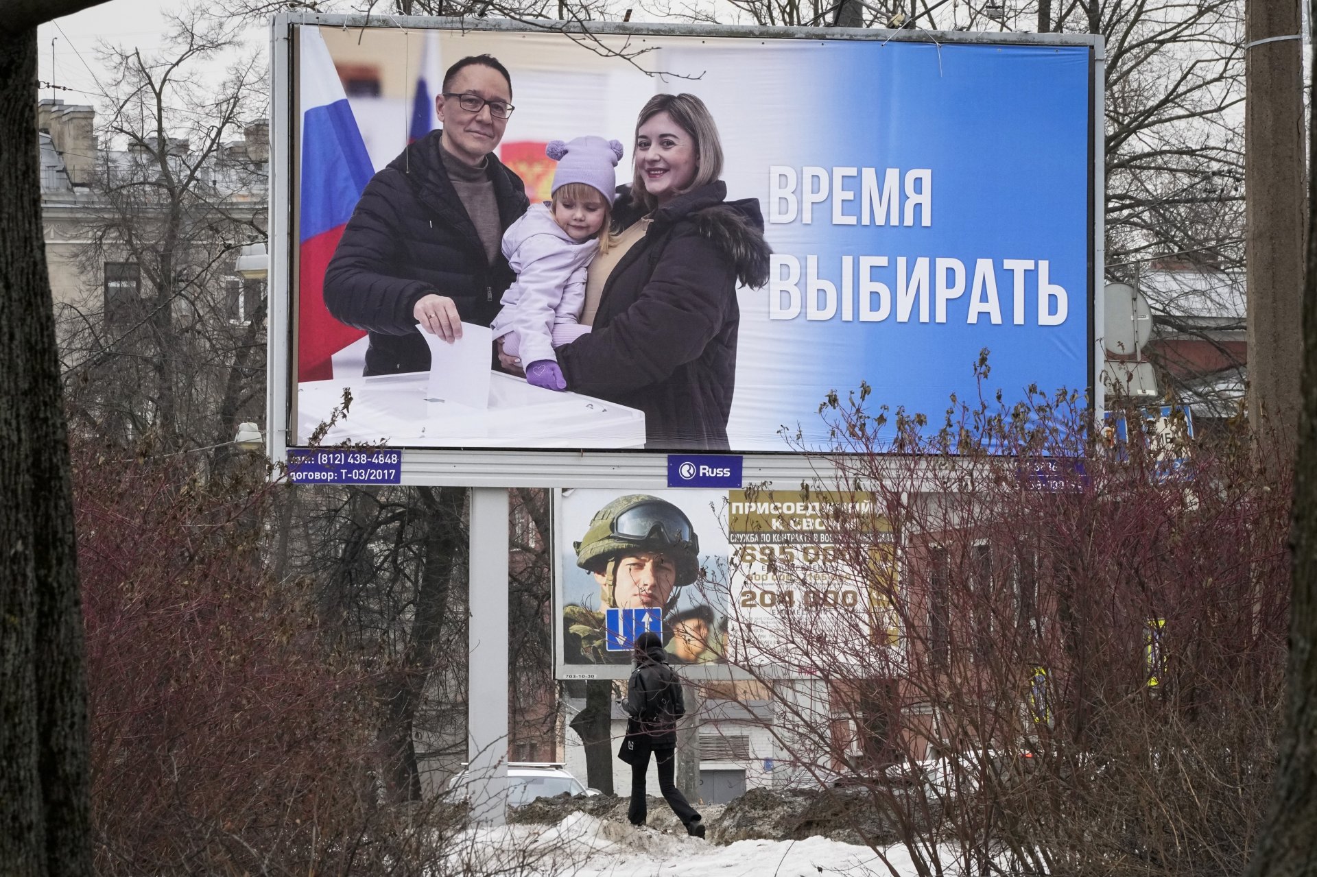 Жителка на Санкт Петербург преминава покрай билборд, призоваващ хората да гласуват на предстоящите президентски избори, 7 март 2024 година
