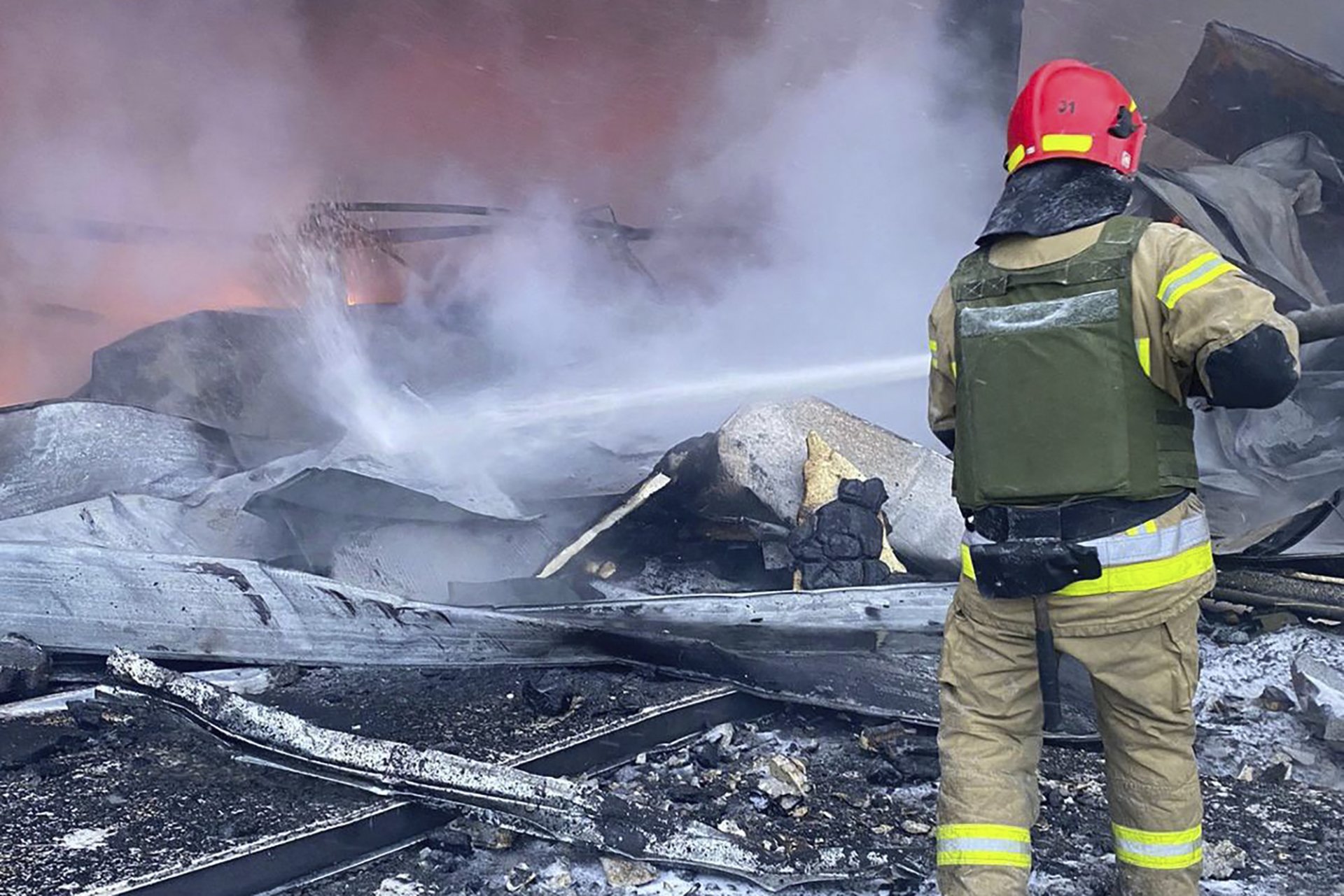 Огнеборец гаси пожар след руска атака срещу Кривой рог на 8 март 2024 г.