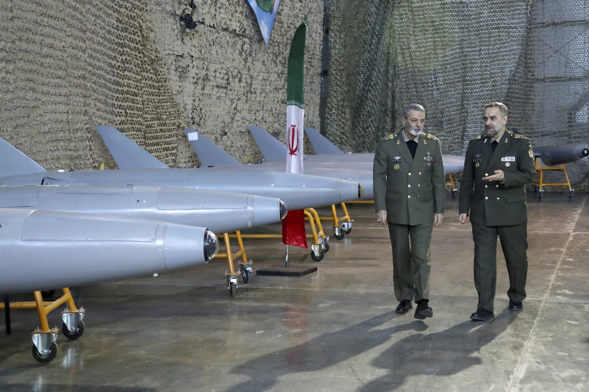Министърът на отбраната на Иран генерал Мохамад Реза Ащияни (вдясно) и главнокомандващия иранските въоръжени сили генерал Абдолрахим Мусави минават покрай произведени в страната им дронове
