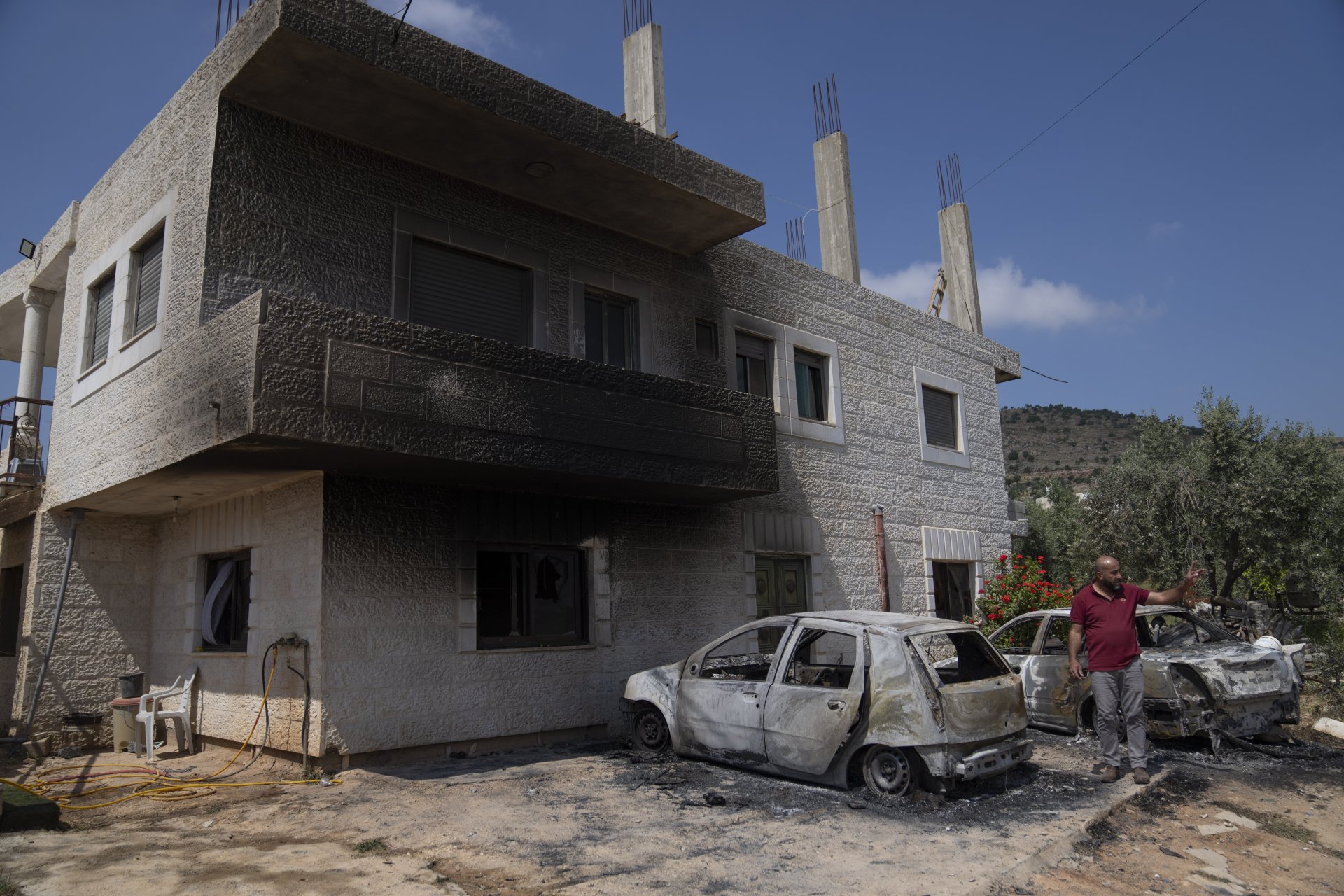 Палестинец оглежда щетите по опожарения си дом и автомобили в село Ал Мугаир на Западния бряг, 13 април 2024 година