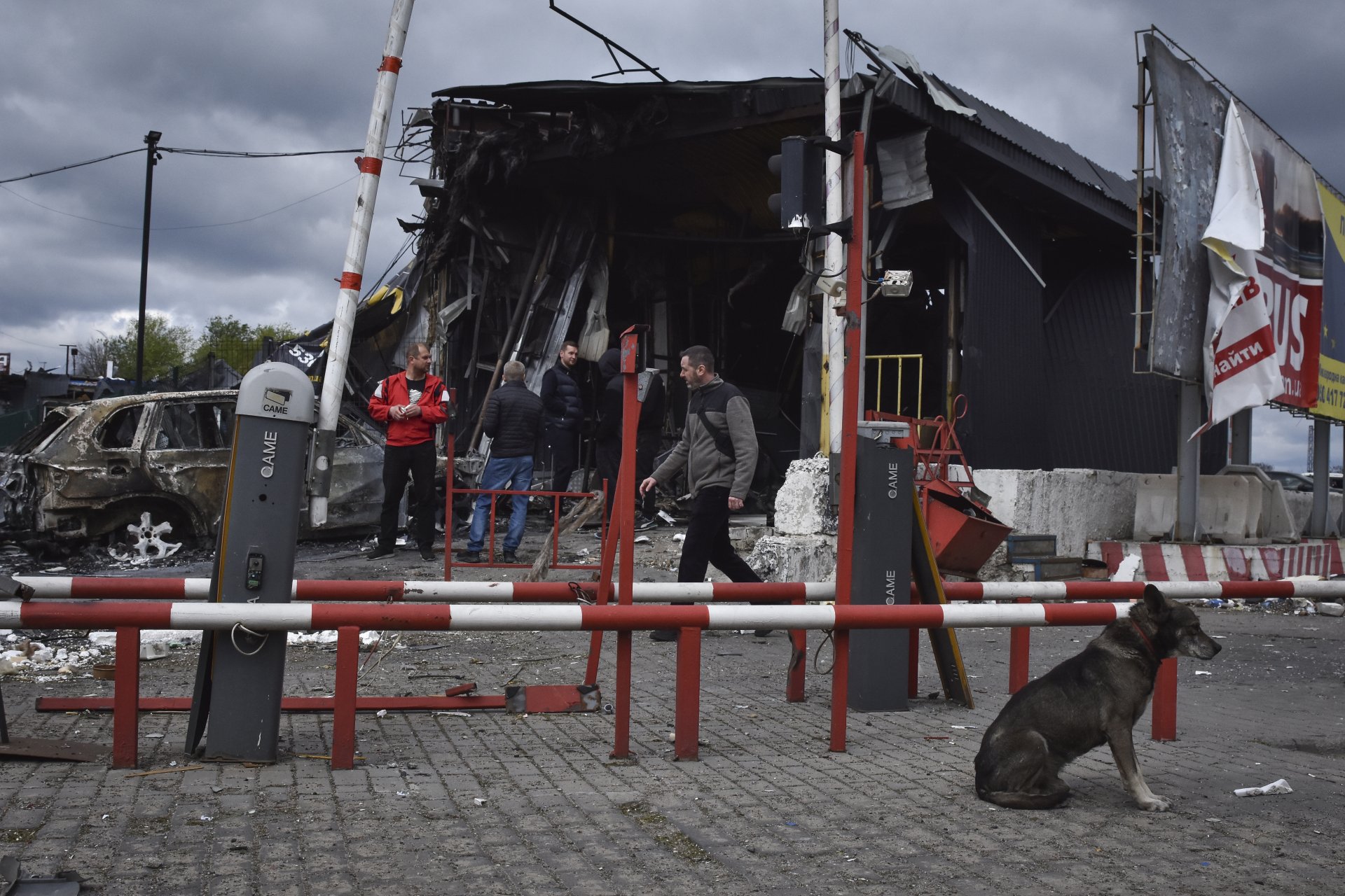 Хора стоят край повредена при руски обстрел сграда в град Днепър