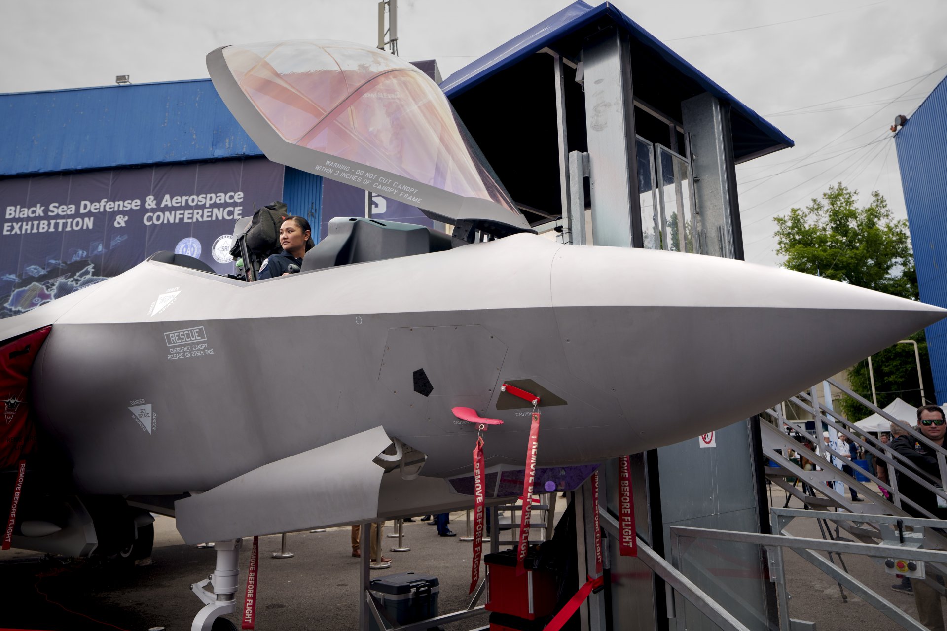 Пилот седи в макет на изтребител F-35 на изложението в Румъния 