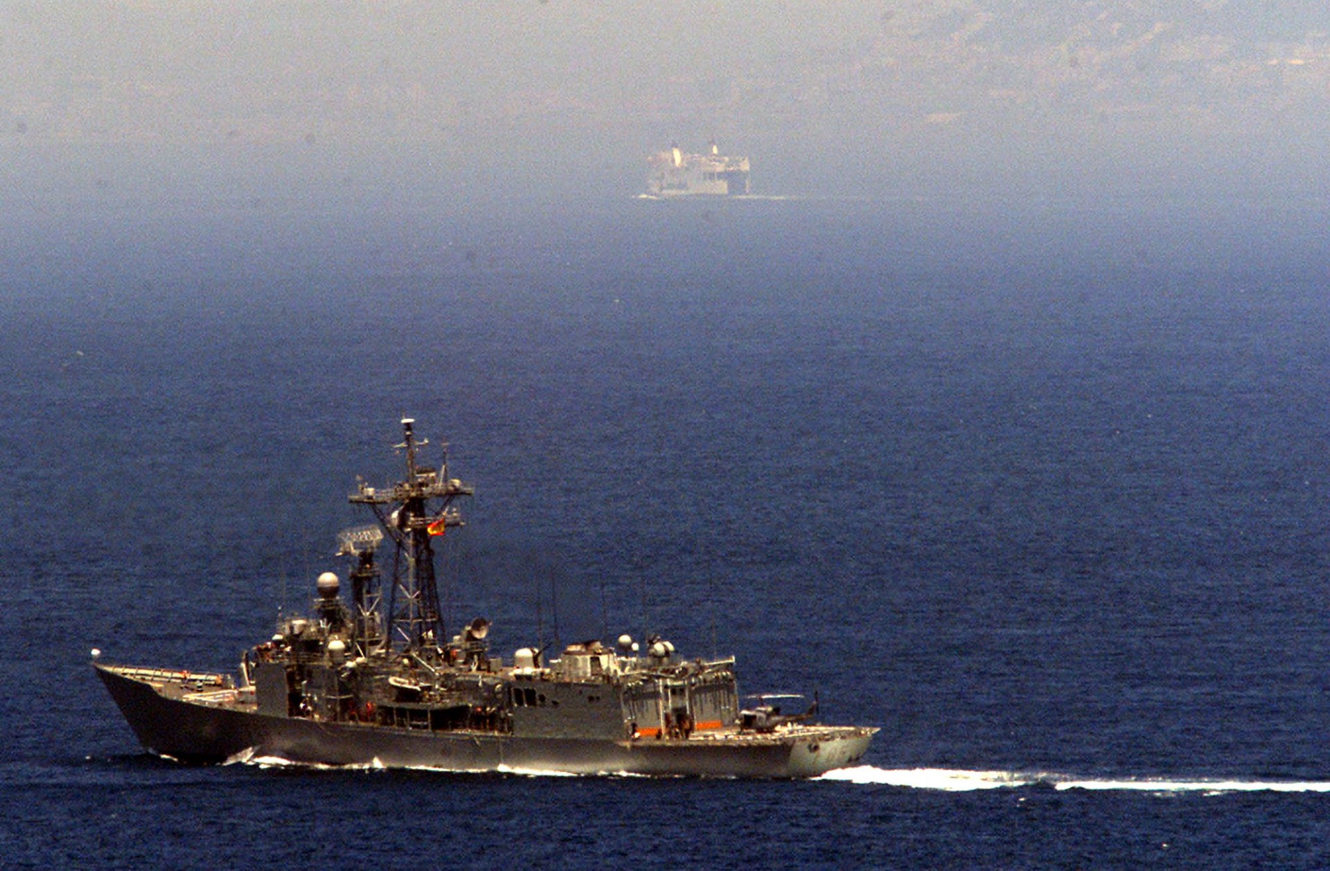 Фрегата на испанския флот патрулира в Гибралтарския пролив близо до остров Перехил, на заден план, гледана от хълмовете на село Белюнеч в Мароко, понеделник, 15 юли 2002 г. 