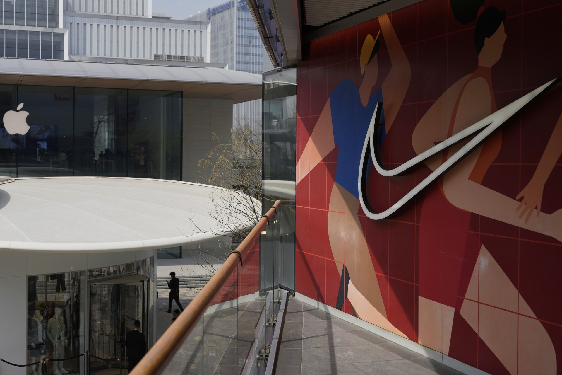 Мъж минава покрай магазини на Apple и Nike в Пекин, петък, 4 април 2025 г.