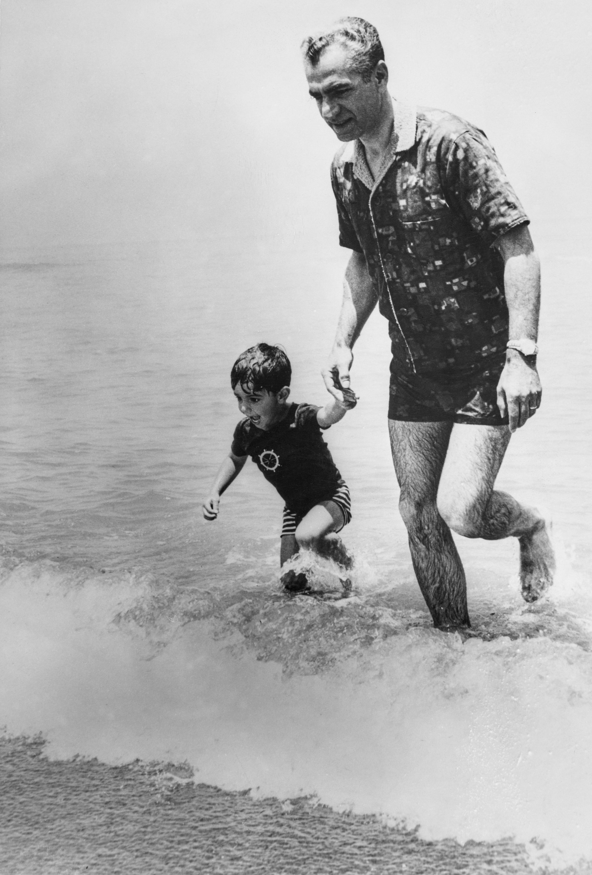 8 юли 1963 г. Невръстният Реза с баща си в Каспийско море на плажа в Ноушахр, Иран