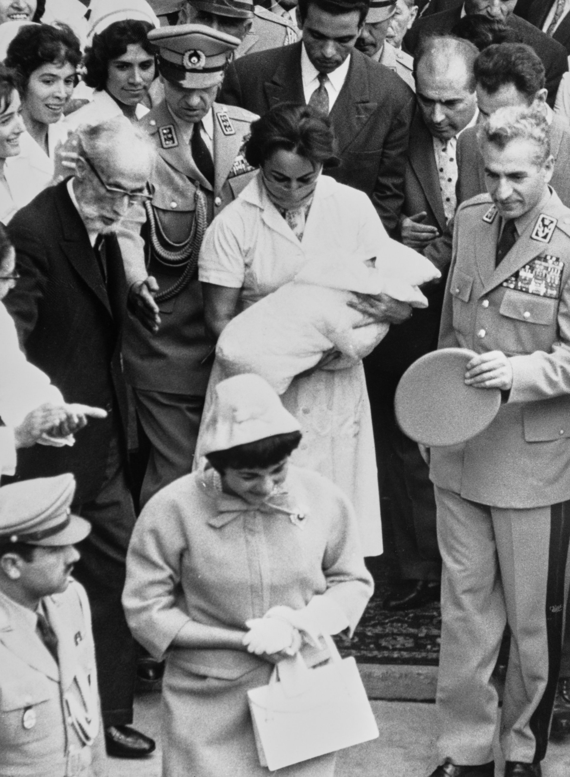 7 ноември 1960 г. Фара Пахлави (на преден план) напуска болницата, последвана от съпруга си Шах Мохамед Реза Пахлави (вдясно) и медицинска сестра, носеща дългоочаквания наследник на иранския трон - новороденият Реза