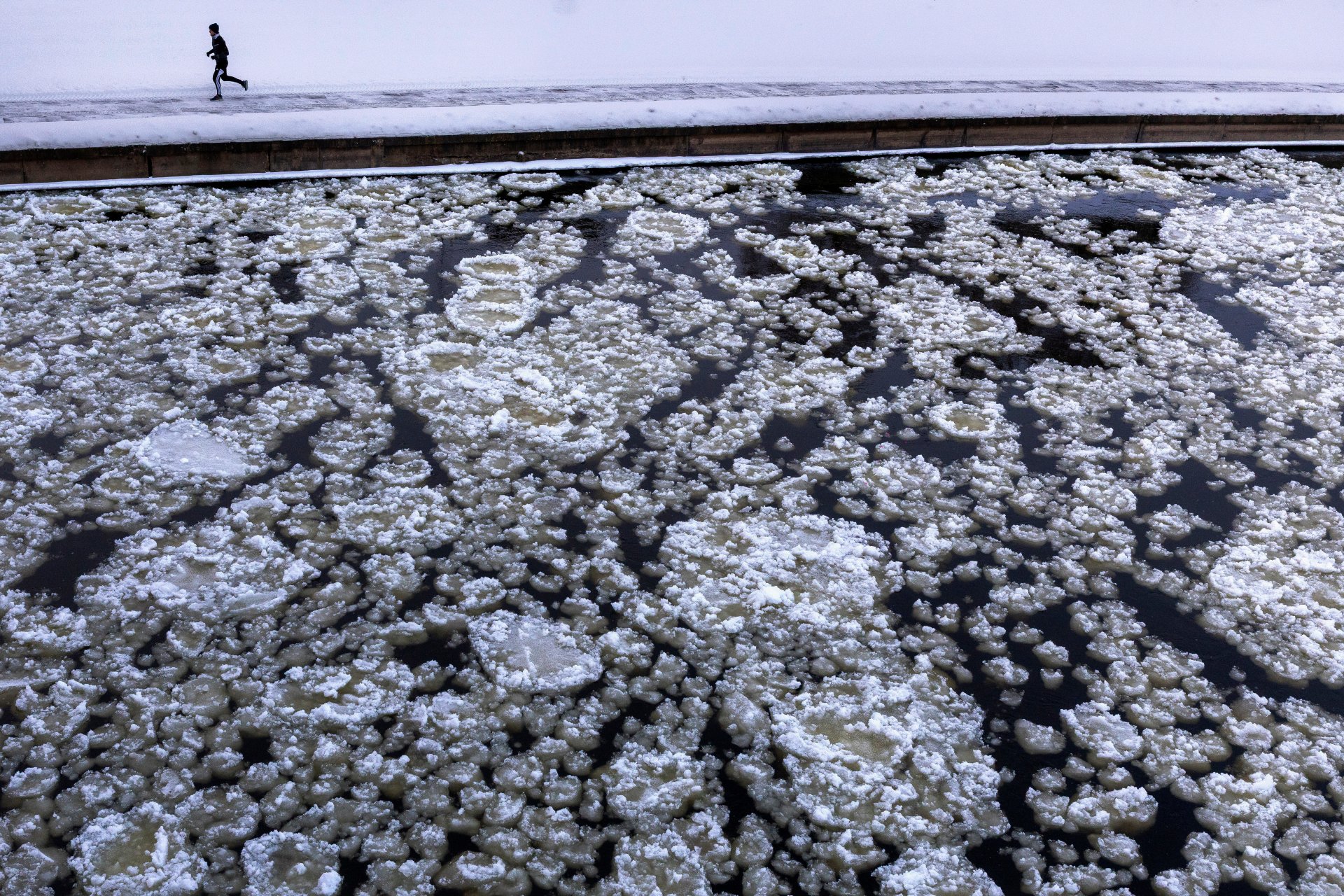 Мъж тича по заснежените брегове на река Нерис, при температура от  -13 градуса по Целзий, във Вилнюс, Литва