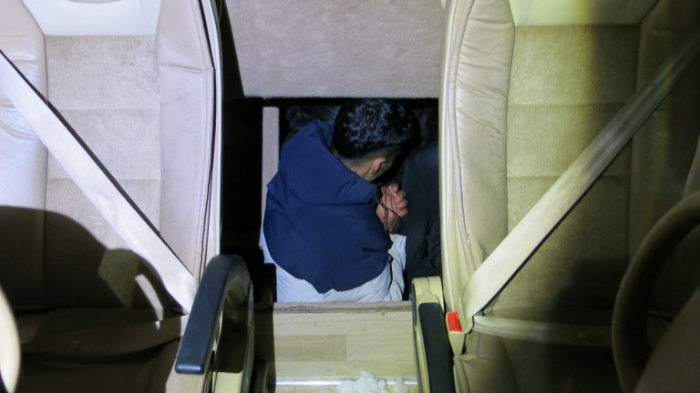 Заловиха 10 мигранти, укрити в тайник на пътнически микробус край Бургас (снимки)