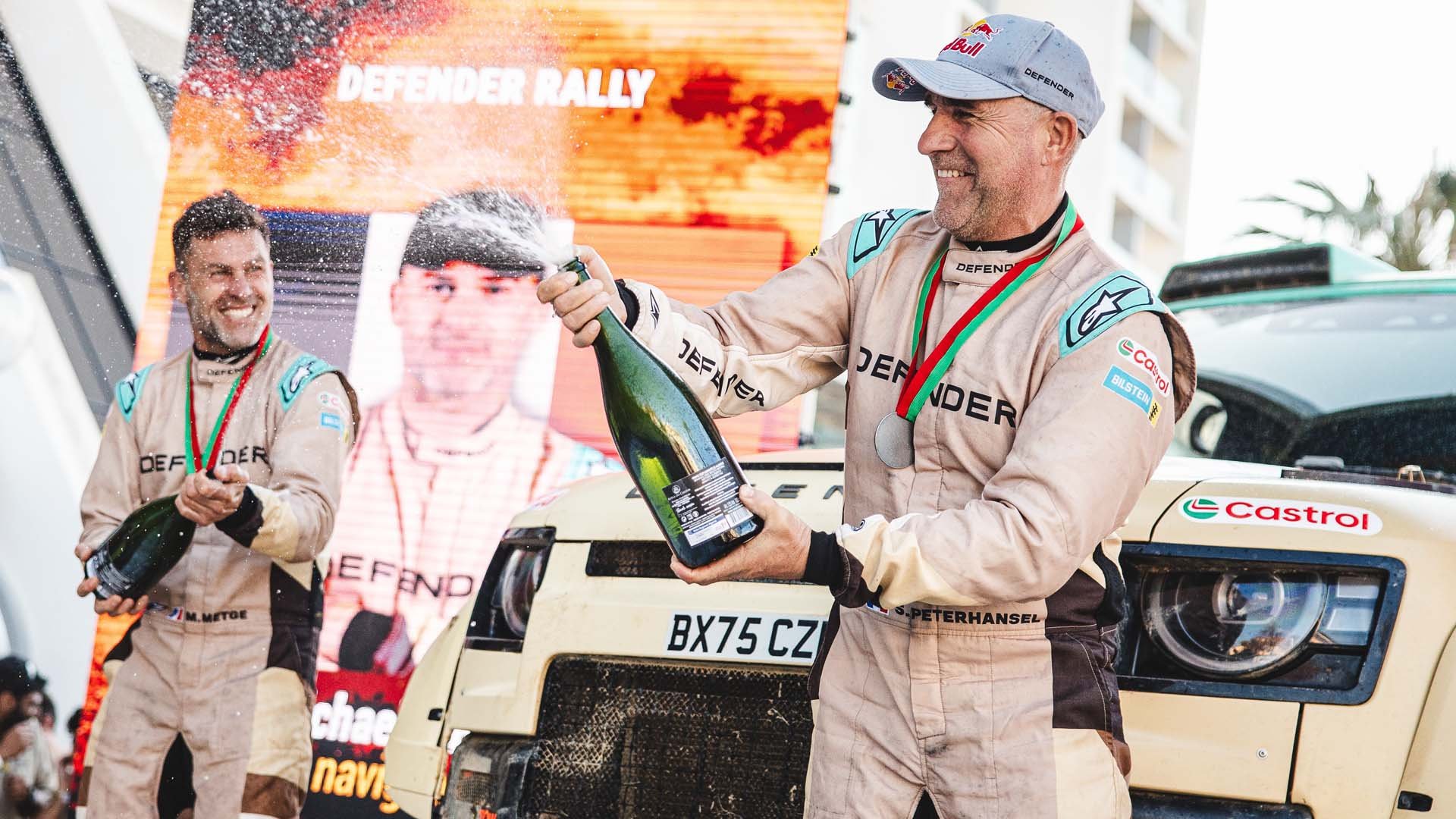 Победителите Стефан Петерхансел и Мика Метге (в ляво) с Defender Dakar D7X-R