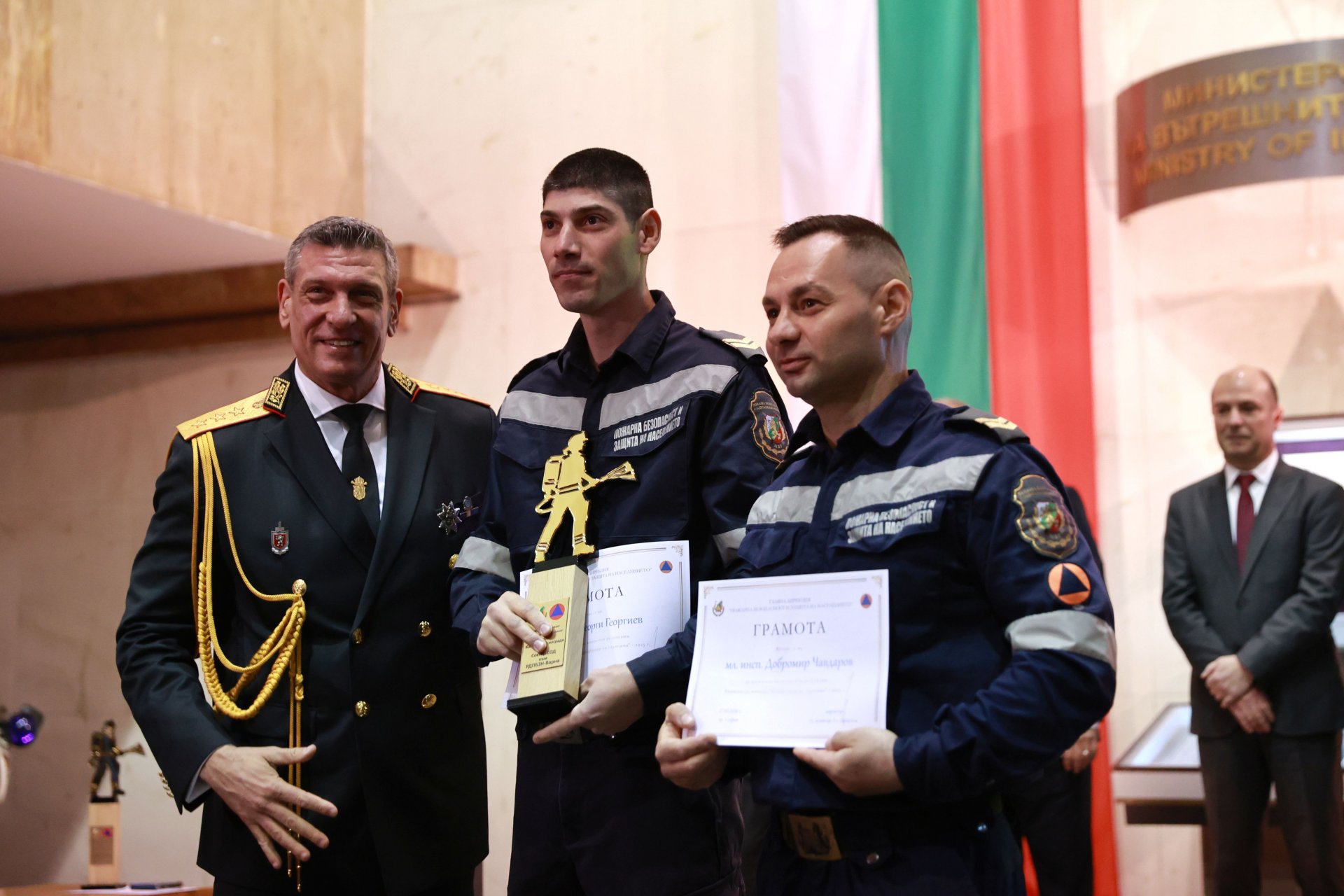 Иизпълняващият функциите главен секретар на МВР Георги Кандев (вляво) връчва Колективна награда за постигане на конкретни резултати, наградата получава екипът на сектор „Специализирани оперативни дейности“ към Регионална дирекция - Варна в състав младши инспектор Добромир Чавдаров и младши инспектор Георги Георгиев.