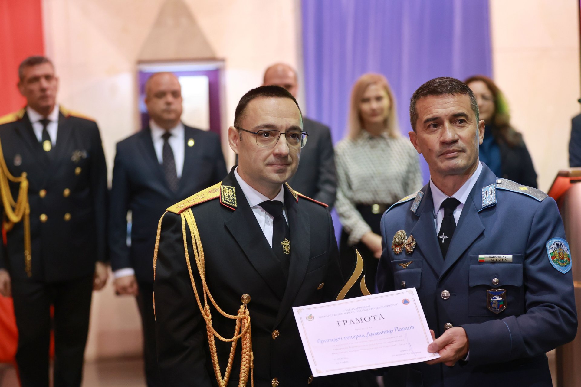 На снимката: директорът на ГДПБЗН главен комисар Александър Джартов (вляво) връчва отличие на бригаден генерал Димитър Павлов